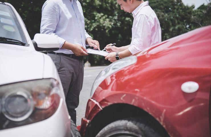 Automobilisti compilano la constatazione amichevole dopo un tamponamento