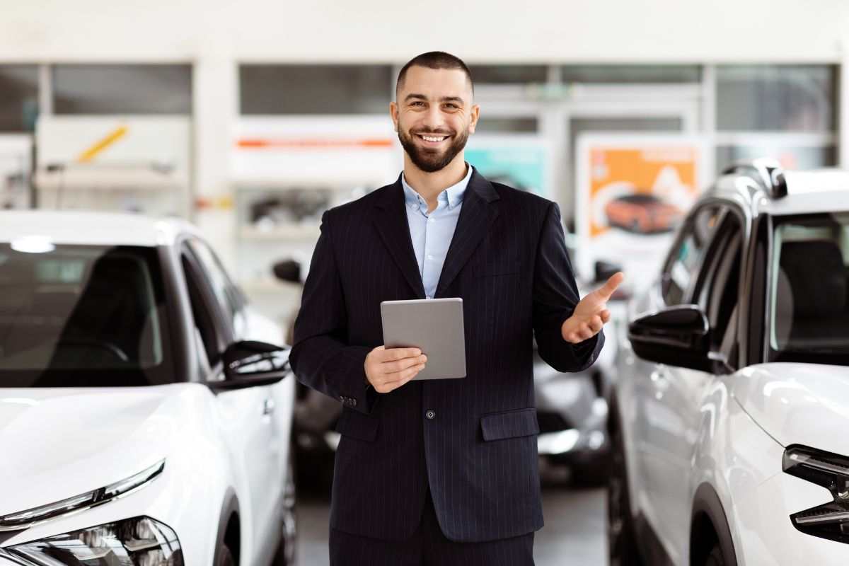 Venditore sorridente nel suo autosalone