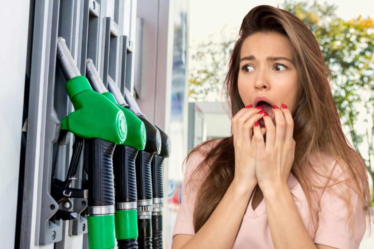 Distributore di carburante a sinistra e a destra una donna spaventata