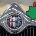 Alfa Romeo logo su frontale auto e il disegno di un maialino verde con un euro rosso