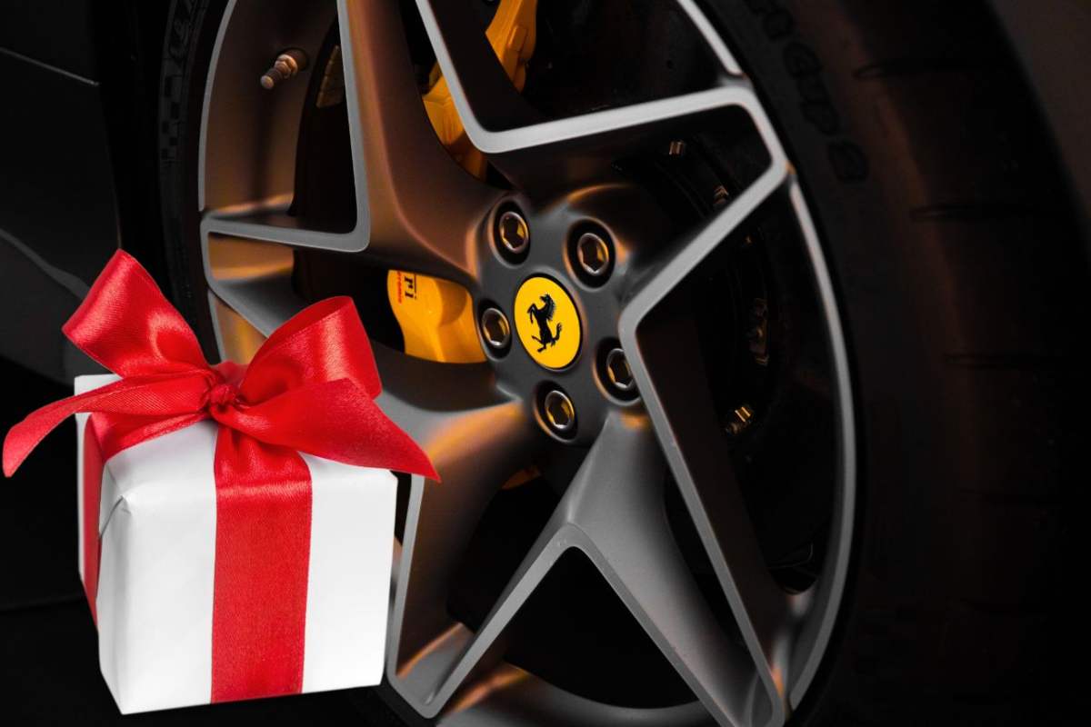 La ruota di una Ferrari con il logo e a sinistra il disegno di un pacco regalo