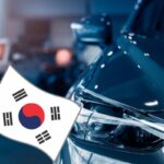 Il dettaglio di un'auto e a sinistra una bandiera coreana