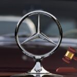 Il logo della Mercedes e a destra il disegno di un martelletto che batte