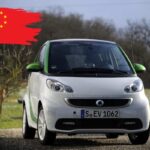 Smart ForTwo in strada e a sinistra la bandiera cinese