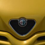 Il logo Alfa Romeo sul frontale di un'auto