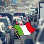 Auto in coda e in mezzo una bandiera italiana