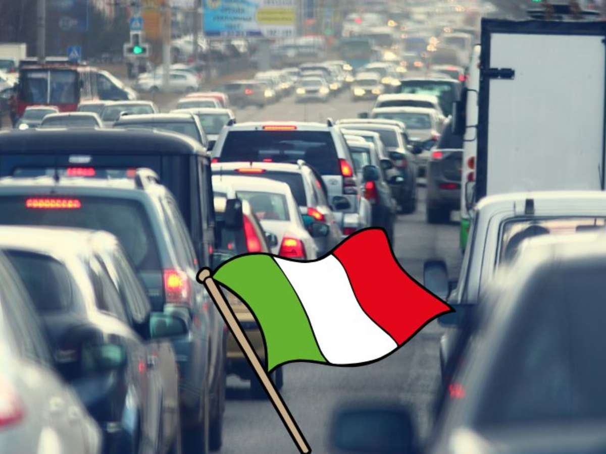 Auto in coda e in mezzo una bandiera italiana