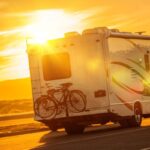 un camper in strada al tramonto