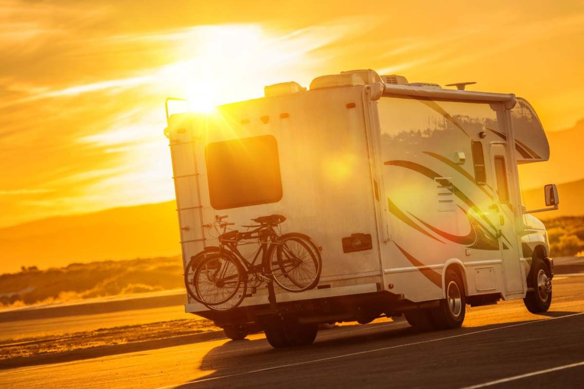 un camper in strada al tramonto